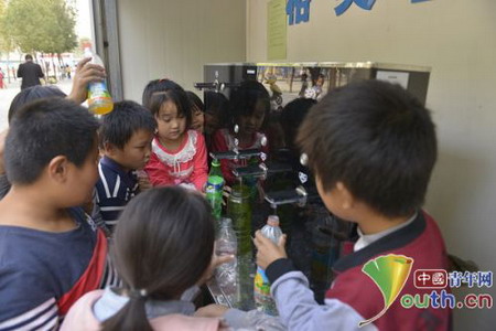 孩子们正在使用安装好的直饮水设备