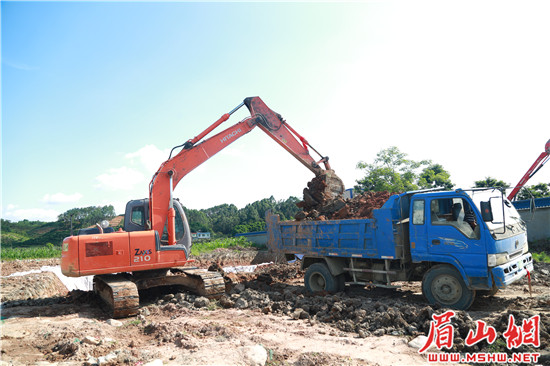图为7月19日，现场机器轰鸣，工人们正冒着高温天气进行部分构筑物基础土方开挖施工。