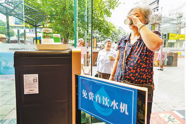 8月24日，九龙坡区杨家坪步行街，设置在和平药房里的免费直饮水机受到市民的欢迎。