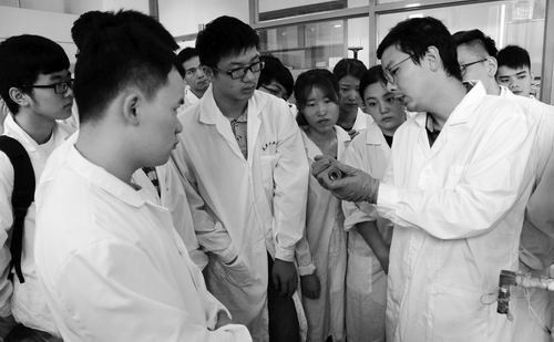天津工业大学材料科学与工程学院副教授黄庆林（右）正在给学生讲课