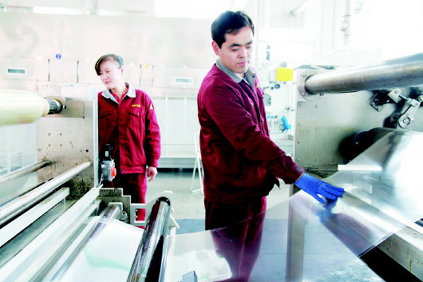 在山东天维膜技术有限公司生产车间，工作人员正在对产出的荷电膜进行检查