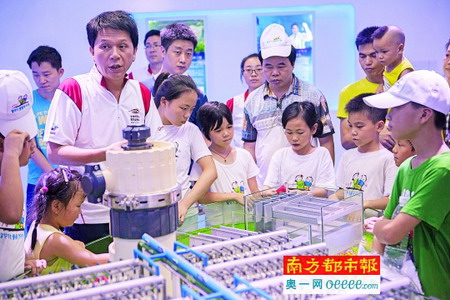 工作人员向孩子们介绍水厂膜处理工艺设备模型 工作人员向孩子们介绍水厂膜处理工艺设备模型