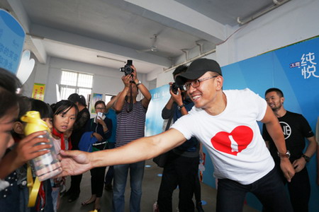 可口可乐志愿者将水杯送到现场的160多名学生手中