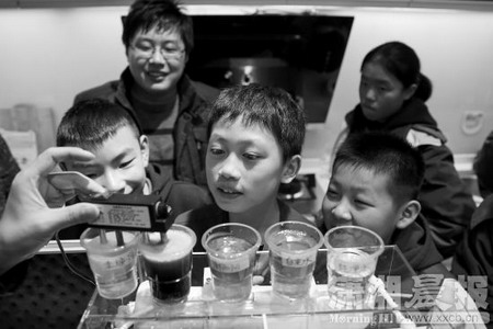 学生们围在一起看工作人员做水质测试实验 学生们围在一起看工作人员做水质测试实验