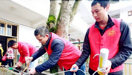 志愿者在布管、安装净水器 志愿者在布管、安装净水器