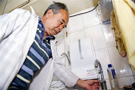 4月19日,乌市水磨沟区七纺片区管委会团结社区,居民牛如端在接自来水,墙上是他买的第三个净水器。由于自来水常年存在沉淀物(小图)、咸味等现象,大多居民家使用净水器过滤水后再饮用 4月19日,乌市水磨沟区七纺片区管委会团结社区,居民牛如端在接自来水,墙上是他买的第三个净水器。由于自来水常年存在沉淀物(小图)、咸味等现象,大多居民家使用净水器过滤水后再饮用