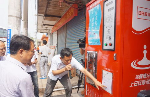 日日顺健康水站总经理宫钦玉(右)向兰陵县县委书记郑连胜(左)现场讲解惠民水站 日日顺健康水站总经理宫钦玉(右)向兰陵县县委书记郑连胜(左)现场讲解惠民水站