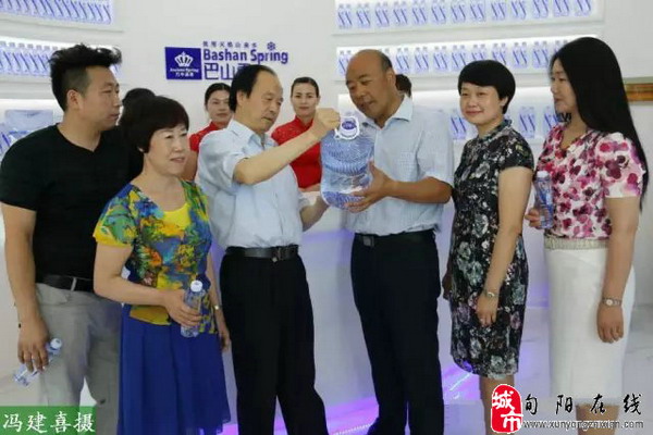 安康巴山雪饮食有限责任公司董事长潘怀宏（右三）向来访的客人介绍巴山雪山泉水