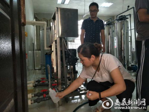 采样人员在学校分质供水制水间采集直饮水样品 采样人员在学校分质供水制水间采集直饮水样品