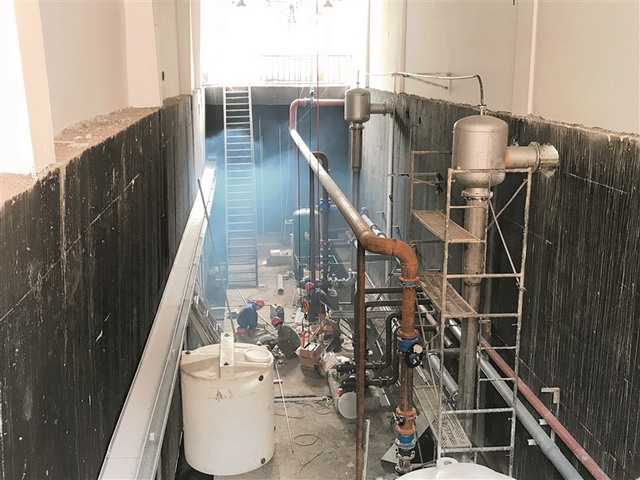 施工人员正在设备间安装管道 施工人员正在设备间安装管道