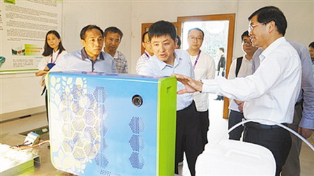 合即得董事长向华(右一)向参观者讲解“水氢机” 合即得董事长向华(右一)向参观者讲解“水氢机”